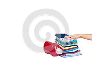 Hand with stack of clothes and detergent bottle, fresh laundry textile