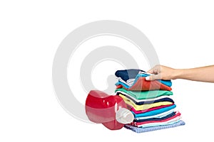 Hand with stack of clothes and detergent bottle, fresh laundry textile