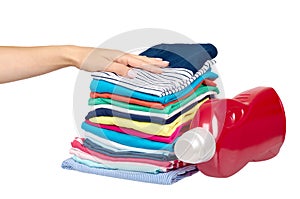 Hand with stack of clothes and detergent bottle, fresh laundry textile