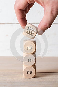 Hand stacking cubes forming the slogan: step by step