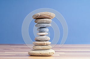 Hand stacking pebbles to make shape of hourglass as a symbol of time management