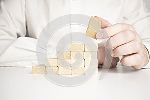 Hand stacking wooden blocks for in shape of staircase. Business development, strategy concept. Building success foundation