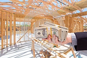 Hand With Stacks of Cash On Site Inside New Home Construction Fr