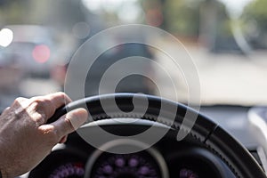Hand on steering wheel while driving in traffic