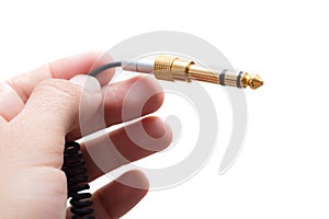 Hand with stereo audio cable gold coated adapter isolated on white background