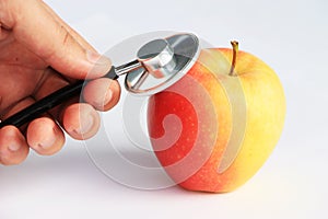 Hand with stethoscope consulting apple