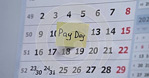 The hand sticks a reminder on the calendar about the meeting. meeting. an important event. reminder card. Pay day