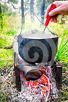 Hand stir the soup in the pot