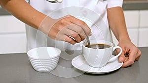 Hand stirring cup of coffee