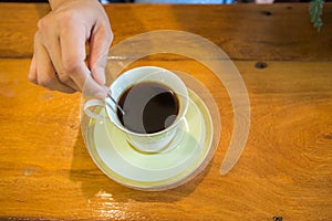 Hand stirring hot black coffee