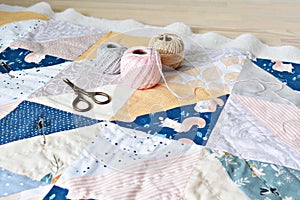 Hand stitch quilting process: cotton thread, needle and scissors