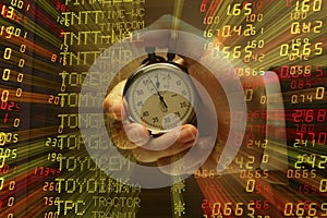 Hand with stop watch with stock index background