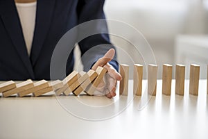 Hand stopping falling blocks on table photo