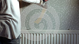 Hand stripping wallpaper from home internal wall close up