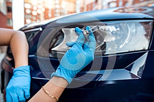 hand of a strong man mechanic hold halogen car lamps against the headlights and repair the car