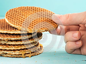 Hand with stroopwafels or caramel Dutch Waffles