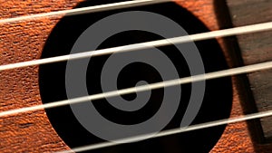Hand strumming guitar strings close up