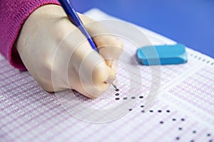 Hand student testing in exercise and taking fill in exam carbon paper computer sheet with pencil at school test room, education