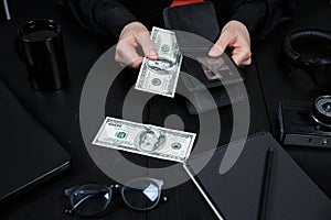 Hand in suit takes out dollar money from a wallet