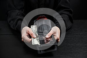 Hand in suit takes out dollar money from a wallet