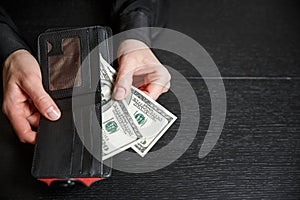 Hand in suit takes out dollar money from a wallet