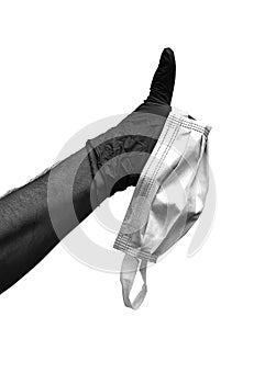 Hand with surgical glove with thumb raised as a sign of success and perfection and surgical mask