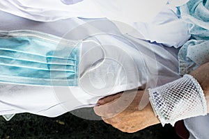 Hand and surgical mask against covid-19 of hospital patient lying in bed