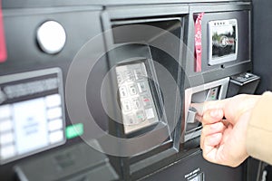 Hand swiping credit card at gas pump station.