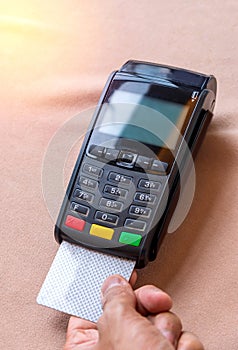 Hand Swiping Credit Card on POS terminal in Store