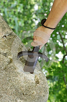 hand and sword in the stone as in the legend of King Arthur