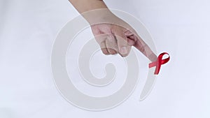 Hand symbol with red ribbon signifying concern for people with HIV aids isolated on white background