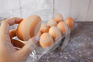 Hand take chicken eggs from a plastic tray, selective focused.