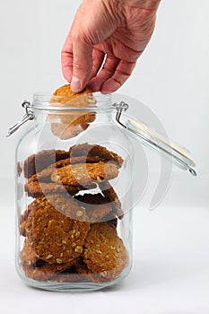 Hand takes biscuit from jar