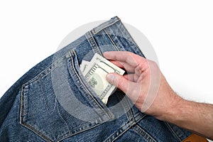 Hand takes dollar bills in the back pocket of jeans