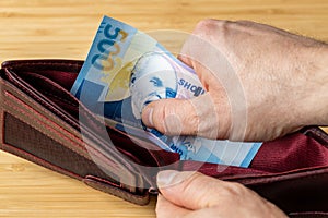 Hand takes money out of wallet, Albania banknote, Economic and financial concept, rising prices, value of Albanian Levs