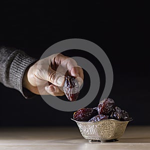 Hand taking the date fruit