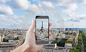 Hand taking photo of Eiffel tower, famous landmark and travel destination in Paris, France by mobile smart phone