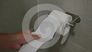 Hand taking toilet paper