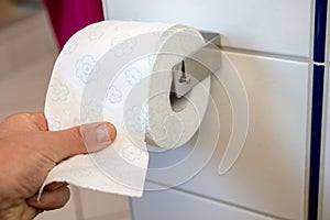 Hand taking white toilet pape