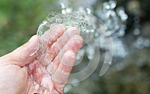 Hand in tap water in nature