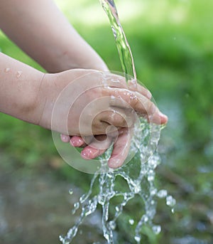 Hand in tap water in nature