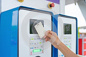 A hand tapping EV charging point card to reader machine. Unlock the station. Electric vehicles battery. Chargeable device or