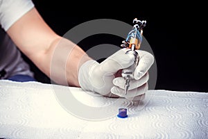 Hand of a tattooer, carefully holding a tattoo device.