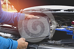 Hand of technician checking engine of car.