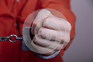 THE HAND OF A TEENAGER IN HANDCUFFS. Concept: juvenile delinquent, criminal liability of minors. Members of youth criminal groups