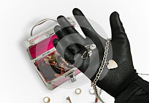 Hand of thief holds and is stealing earrings