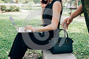 hand of thief will steal the bag behind the woman, who sit and t