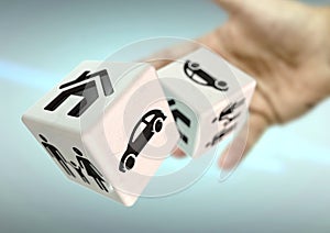 Hand throwing 2 dice with home, family and car symbols. Concept