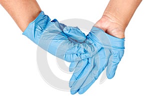 Hand throwing away blue disposable gloves.