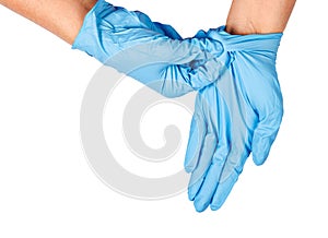 Hand throwing away blue disposable gloves.